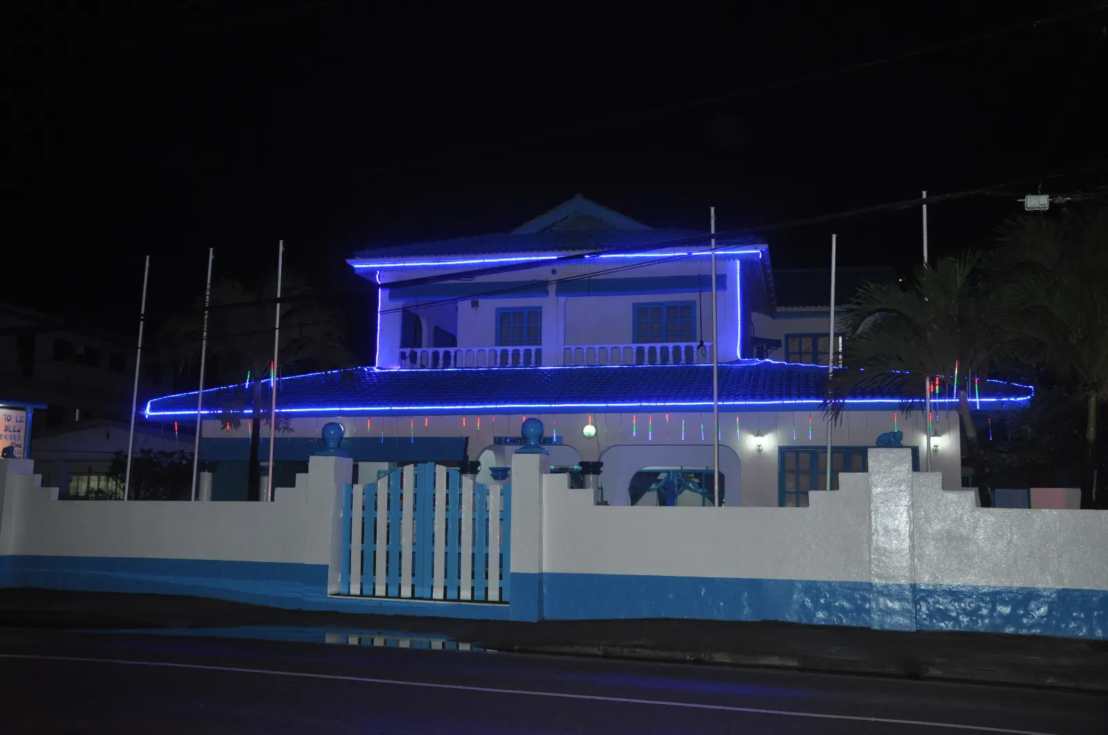 Le Chateau Bleu bei Nacht mit blauen Lichtern entlang Dach und Geländer
