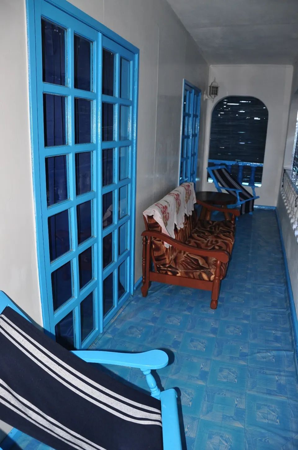 Veranda mit blauer Holztür und gefliestem Boden