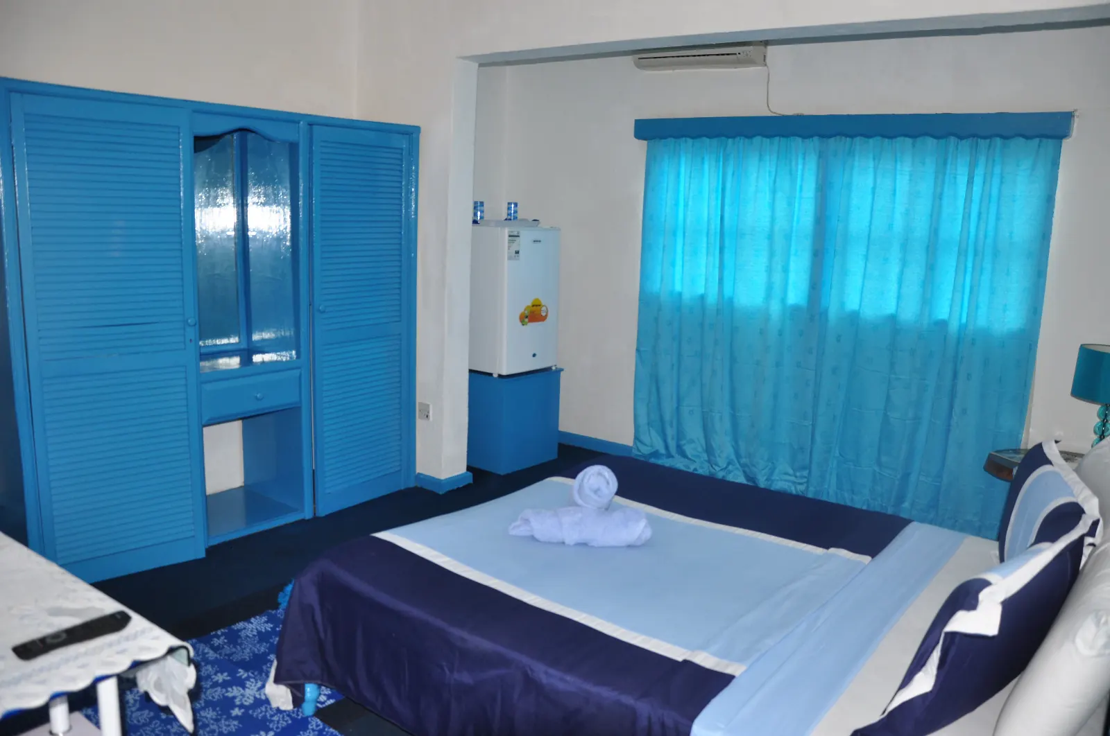 Standardzimmer mit Doppelbett und blauen Vorhängen